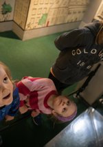 3 siblings of different ages look up in gallery