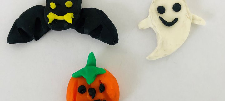 Black bat, white ghost and orange pumpkin creations in clay