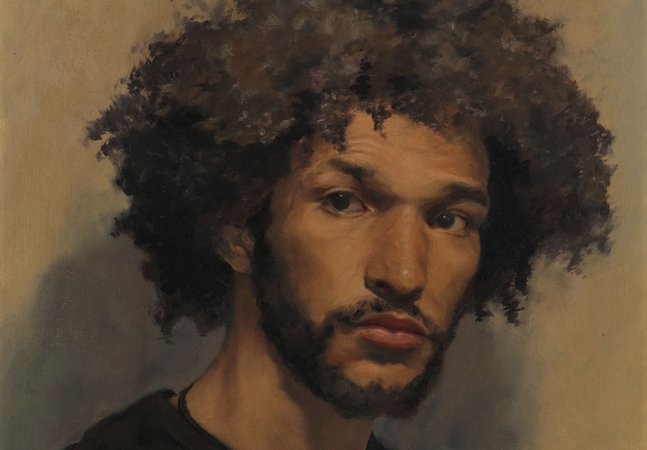 A portrait of a young man against a brown backdrop.