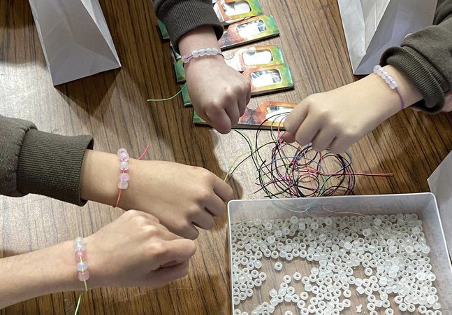 image of four girls wrist with UV bracelets on