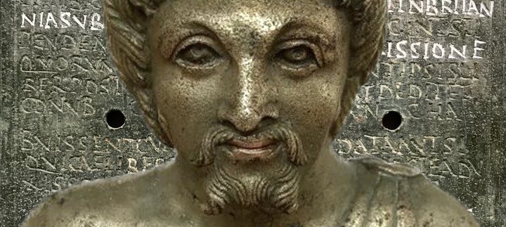 A metal vessel, designed in the shape of a male head and shoulders.