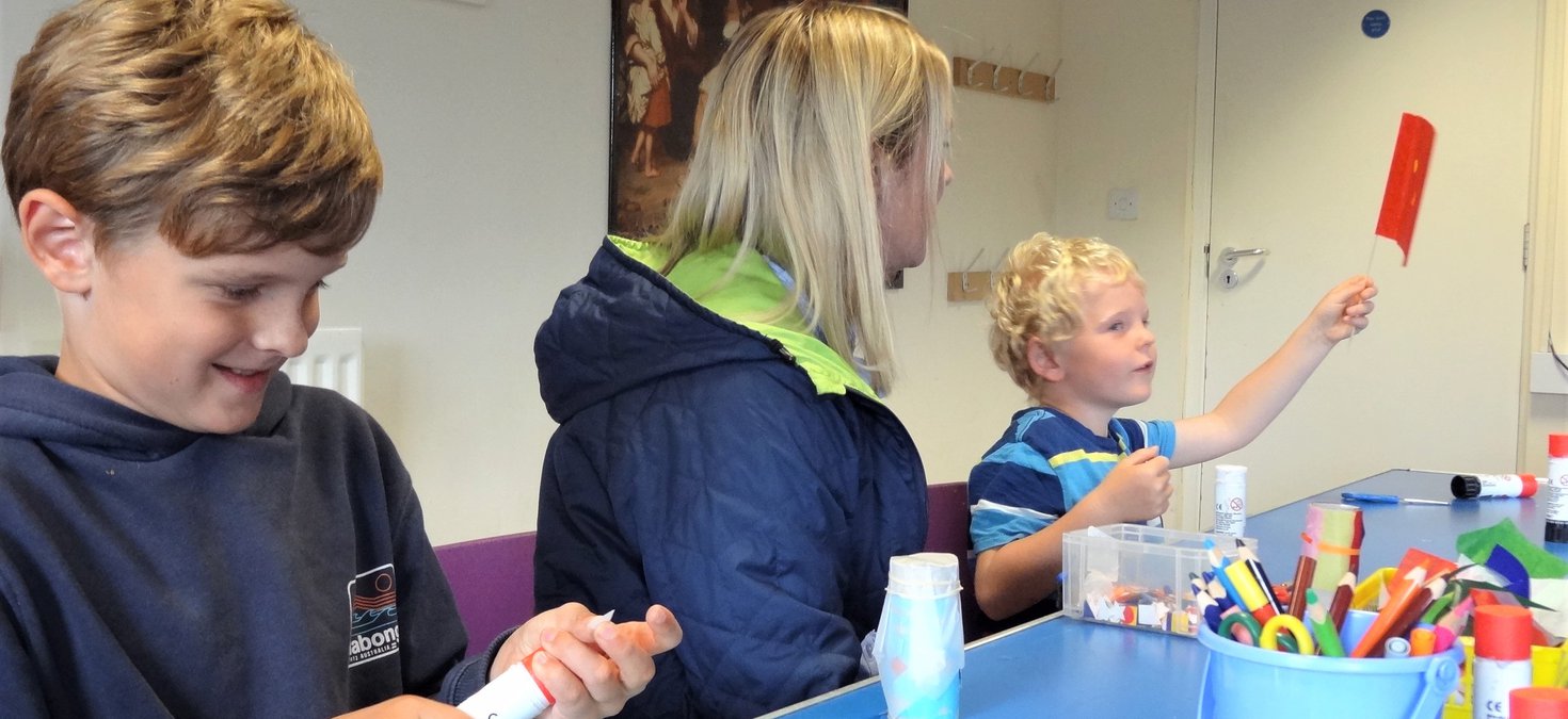 Mother and two boys making flags