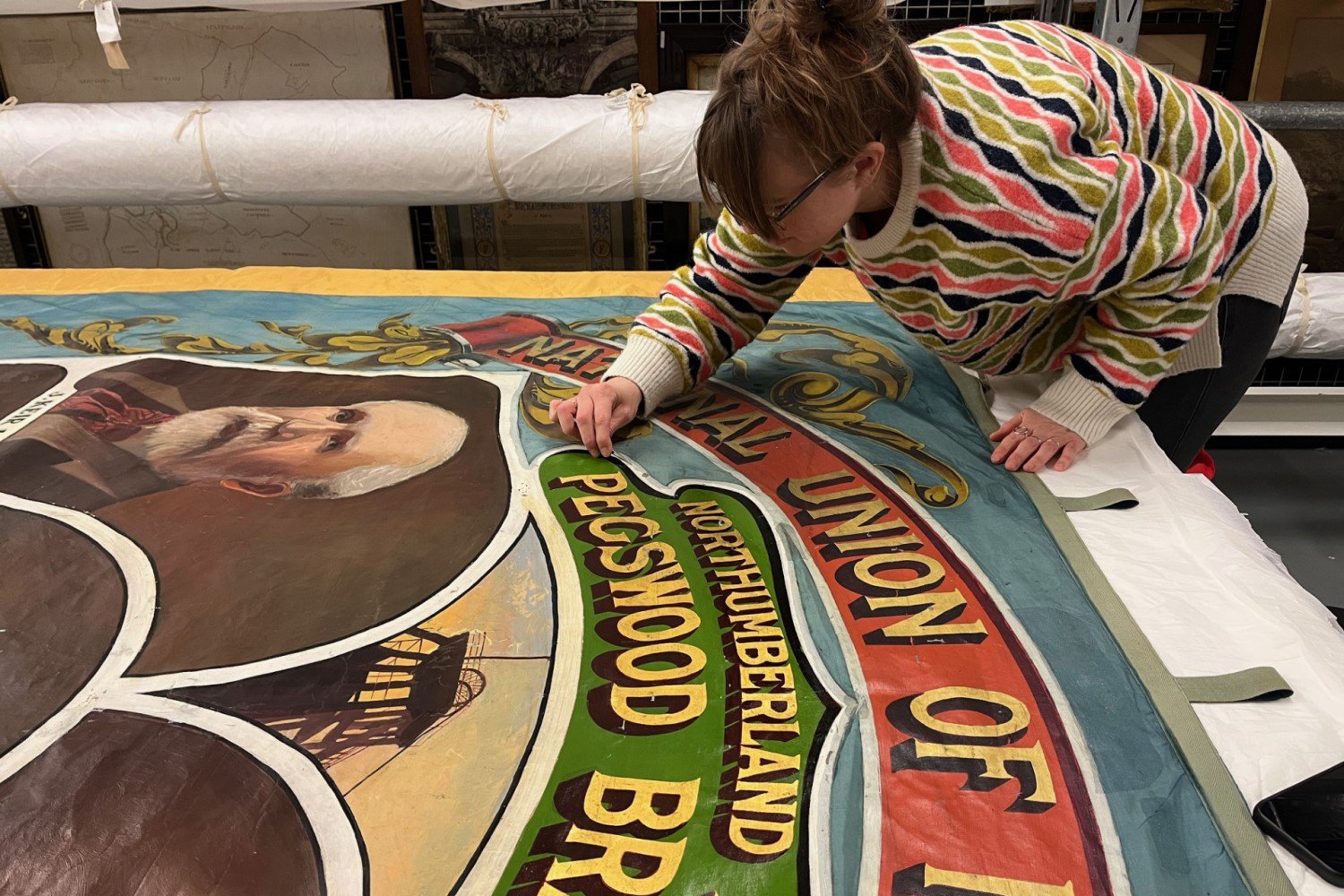 A conservator conserving a mining banner A conservator conserving a mining banner