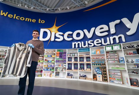 Man holds Jackie Milburn shirt in Discovery Museum
