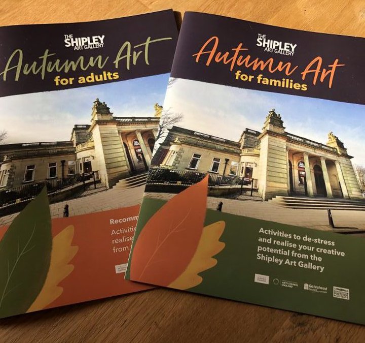 photo of someone holding two autumn art booklets in their hand
