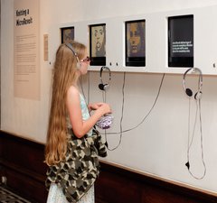 Girl listening to audio recording in gallery