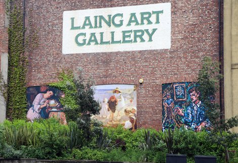 A close up of the exterior of the Laing Art Gallery. The brickwork includes three artworks