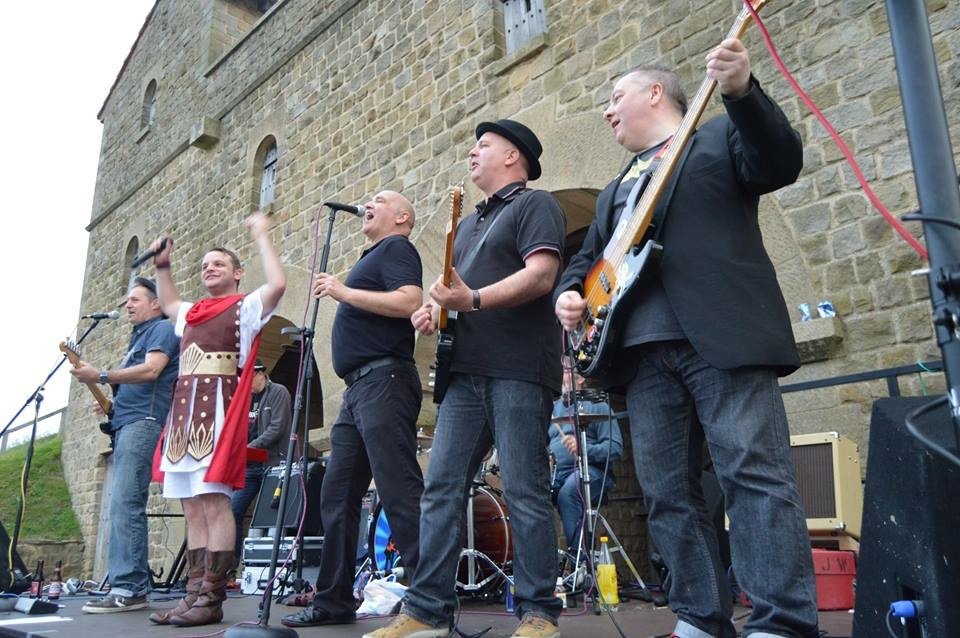 A rock band playing at a Roman Fort.