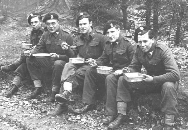 Cpl. Lucas and crew, 15th/19th Hussars, having lunch by the roadside before crossing the Rhine, March, 1945.