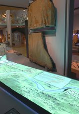 Illuminated map of Hadrian's Wall in a museum gallery with Roman artefacts