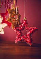 A photograph of a red sequin star Christmas ornament