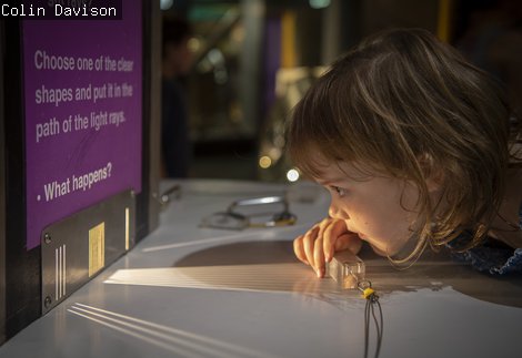 Girl holds a prism in a light 