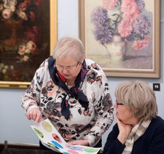 two women looking at a watercolour painting