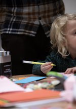 A young child holds a felt-tip. 