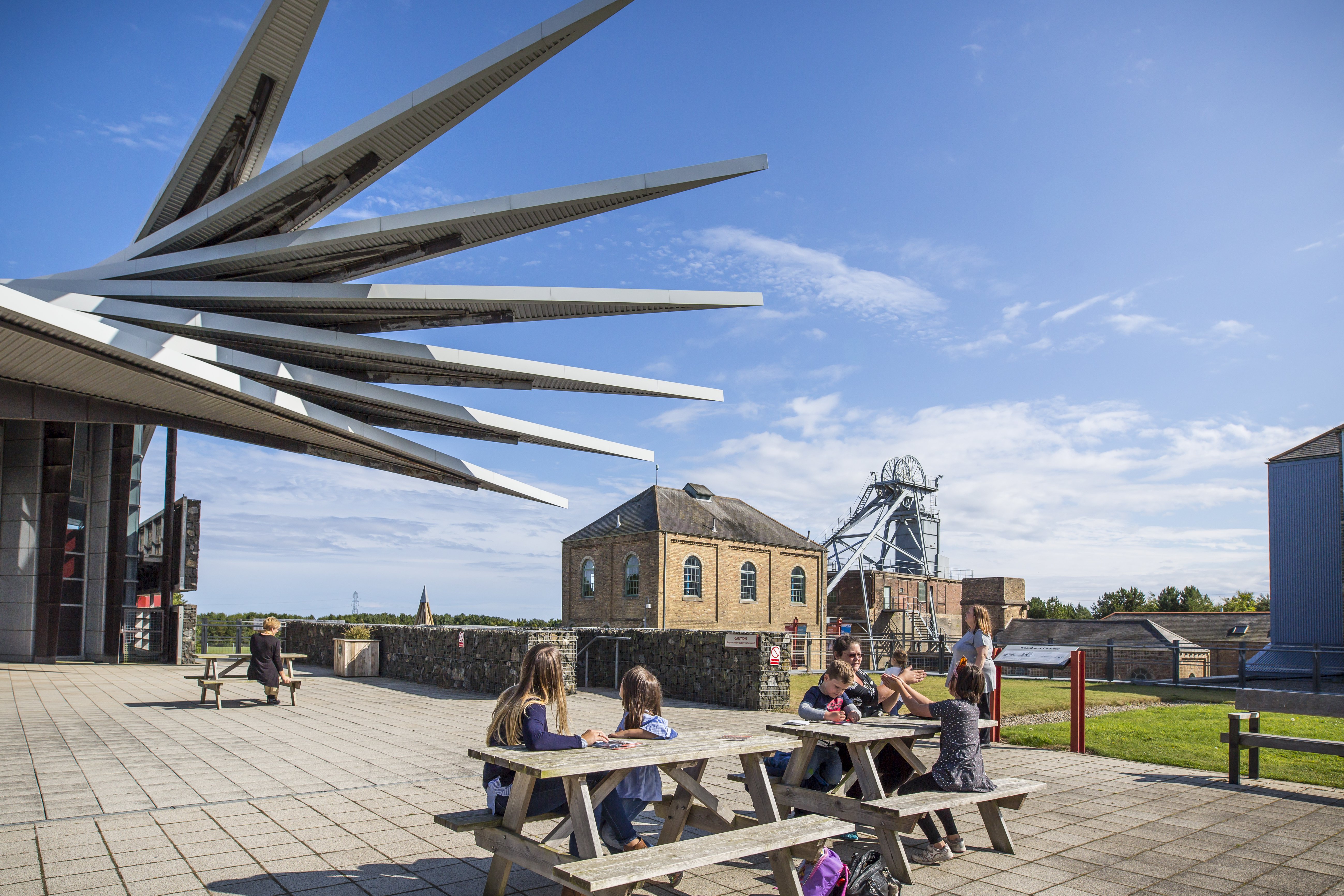 Families sit on picnic benches outside of the Cutter Building at Woodhorn Museum