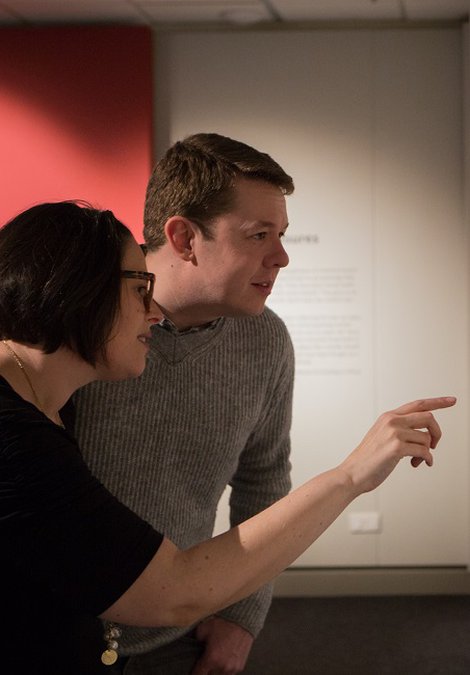 People look at paintings in the gallery