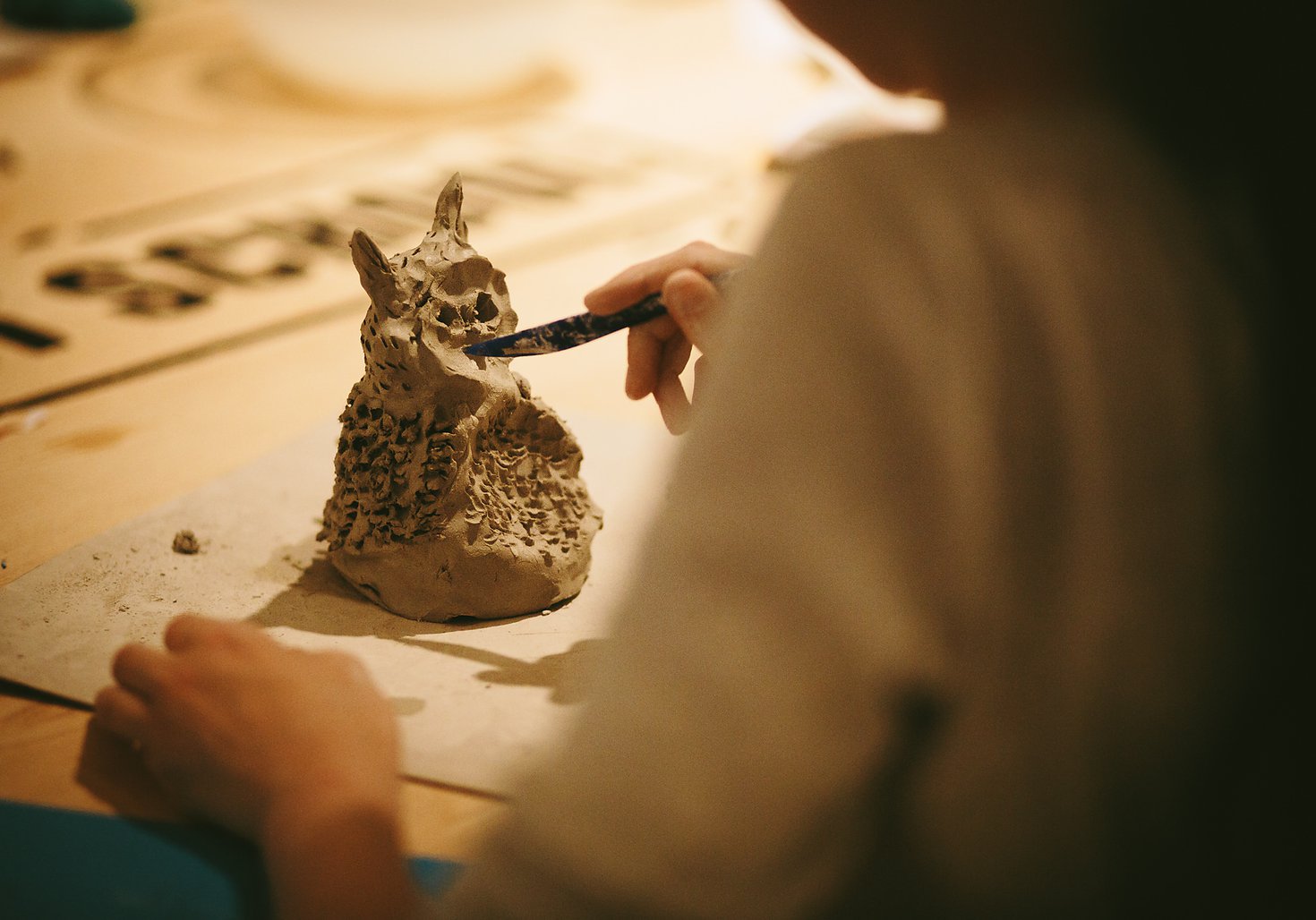 Girl making a clay panda sculpture 