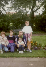 A grainy 1990s photo of a family smiling 