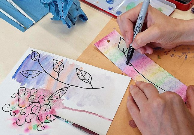 A hand watercolour painting a bookmark.