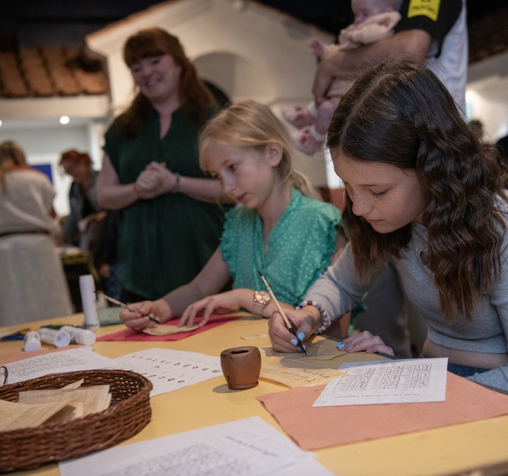 Children sitting at a table working on crafts