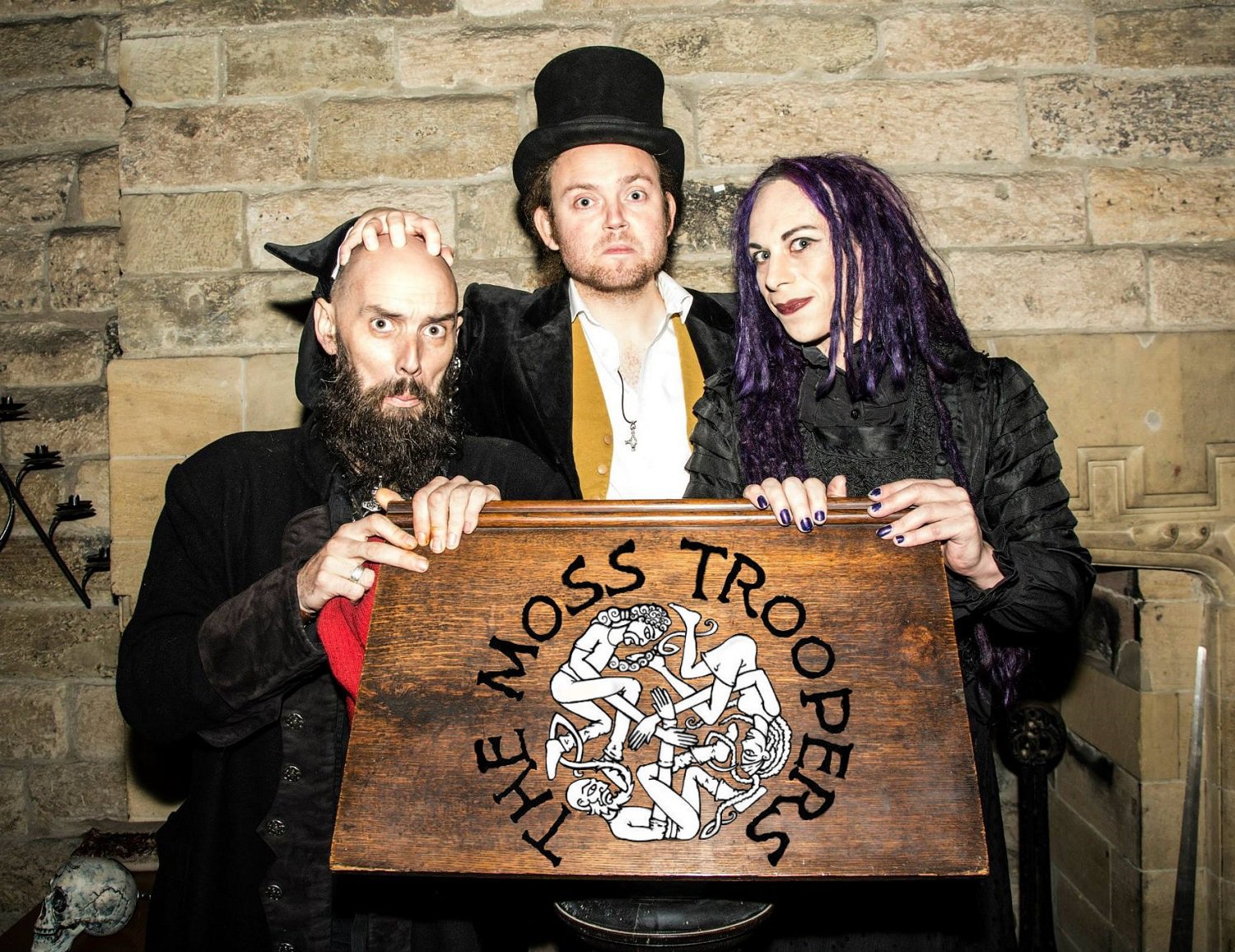 Three entertainers in spooky outfits.