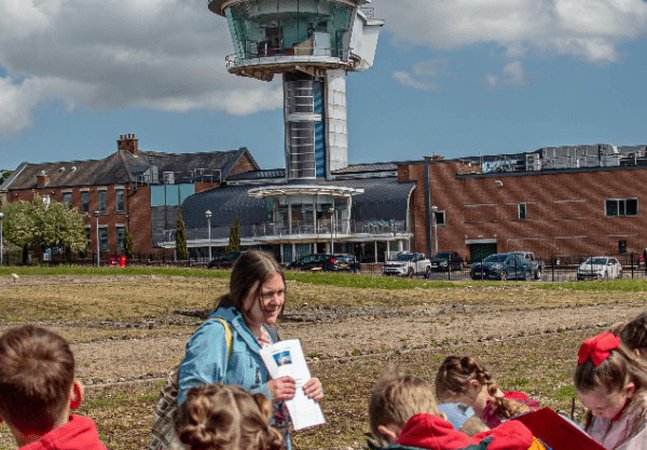 School children on the fort site with viewing tower in the background