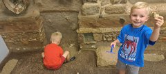 Two boys in Time Quest - 1 is digging and 1 is holding up an object, 