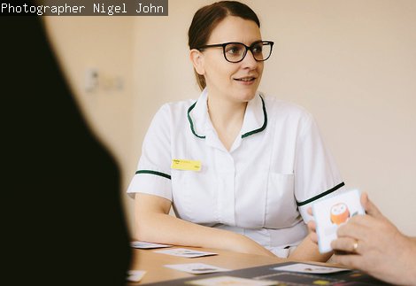 A care worker playing a board game with clients