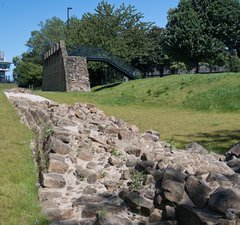 Section of Hadrian's Wall at ground level with Segedunum's viewing tower in the background