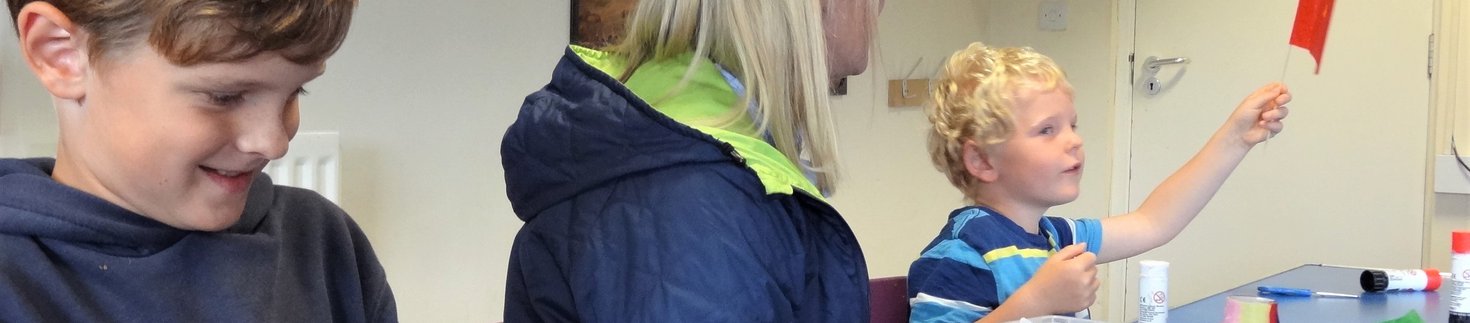 Mother and two boys making flags