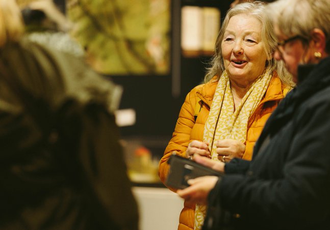 women smile and laugh together in gallery