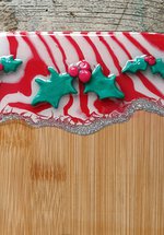 A photograph of a serving board with holly decorations.
