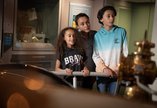 A woman and two children looking at a museum exhibit which is out of view