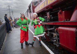 Elves in green elf costumes at the Elf Express, a magical heritage railway Christmas train ride experience.