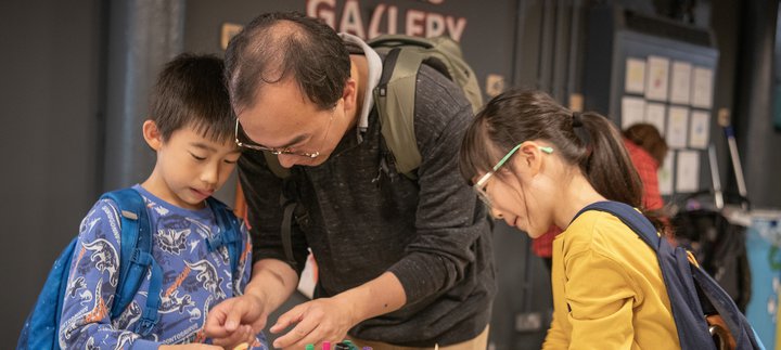 Dad and two children engrossed in craft