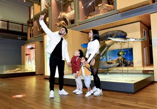 Family of four taking selfie in museum
