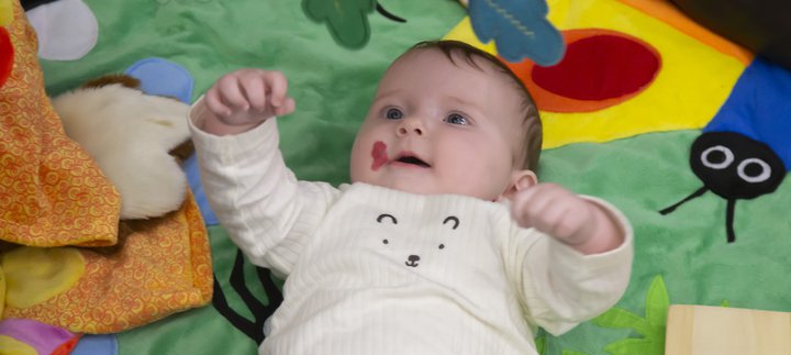 A baby is laying on a sensory mat.