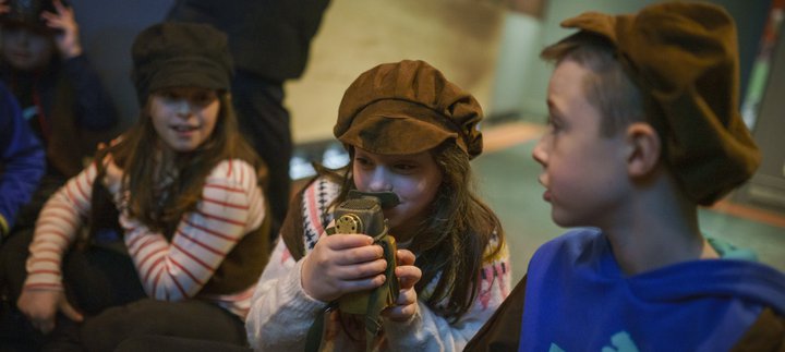 Children sat looking through a looking glass as part of a workshop at Woodhorn Museum.