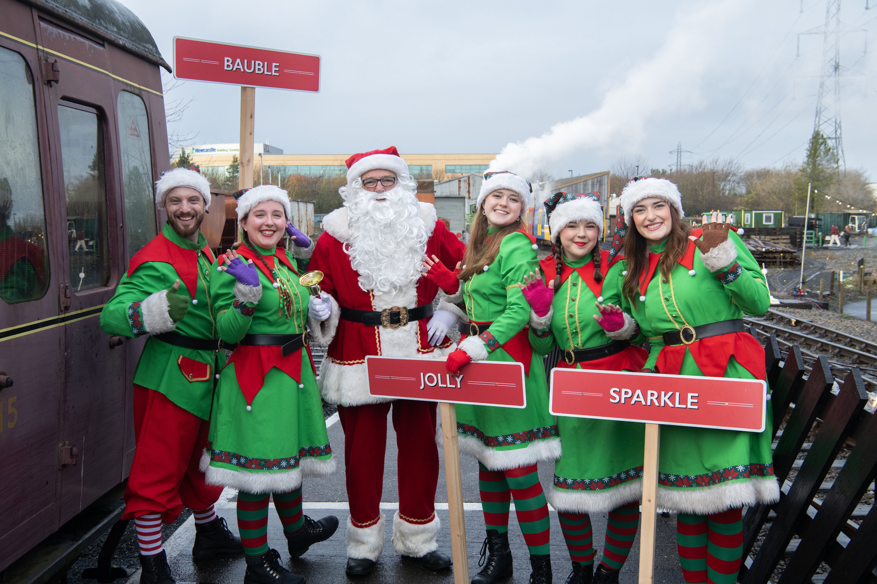 The Elf Express - Santa and Elves stand outside a steam train The Elf Express - Santa and Elves stand outside a steam train