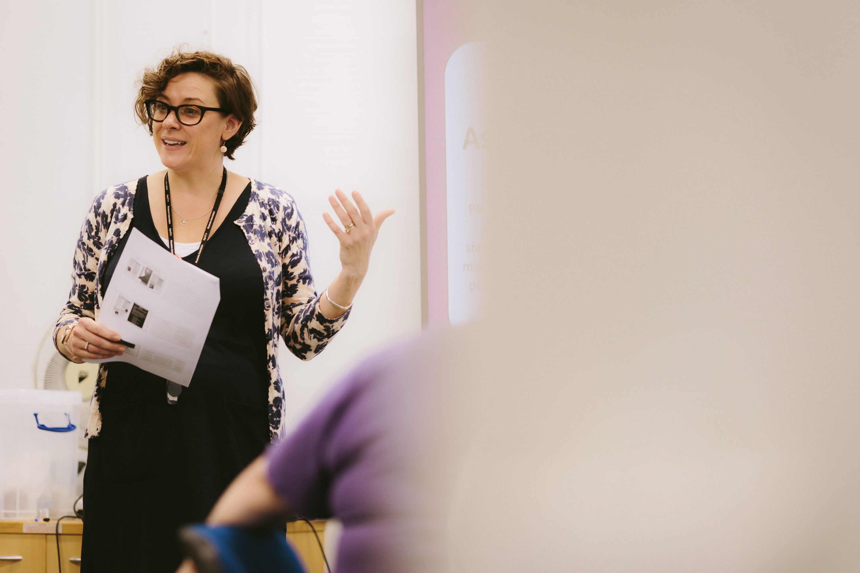 A woman talking to a group as part of a museum workshop.