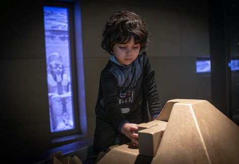 A boy is playing with a children's build a pyramid interactive