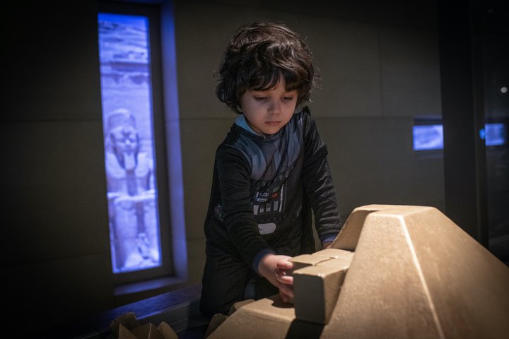 A boy is playing with a children's build a pyramid interactive