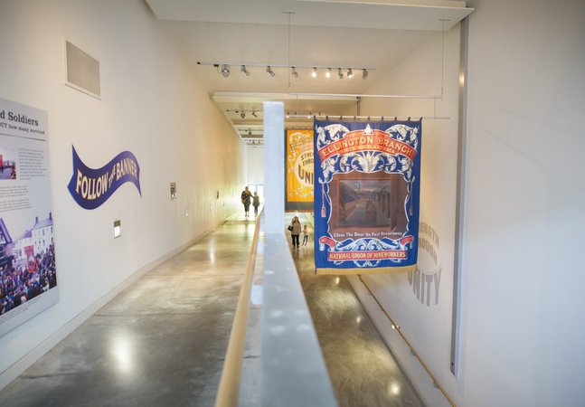A family walks up an indoor ramp with mining banners hanging from the ceiling