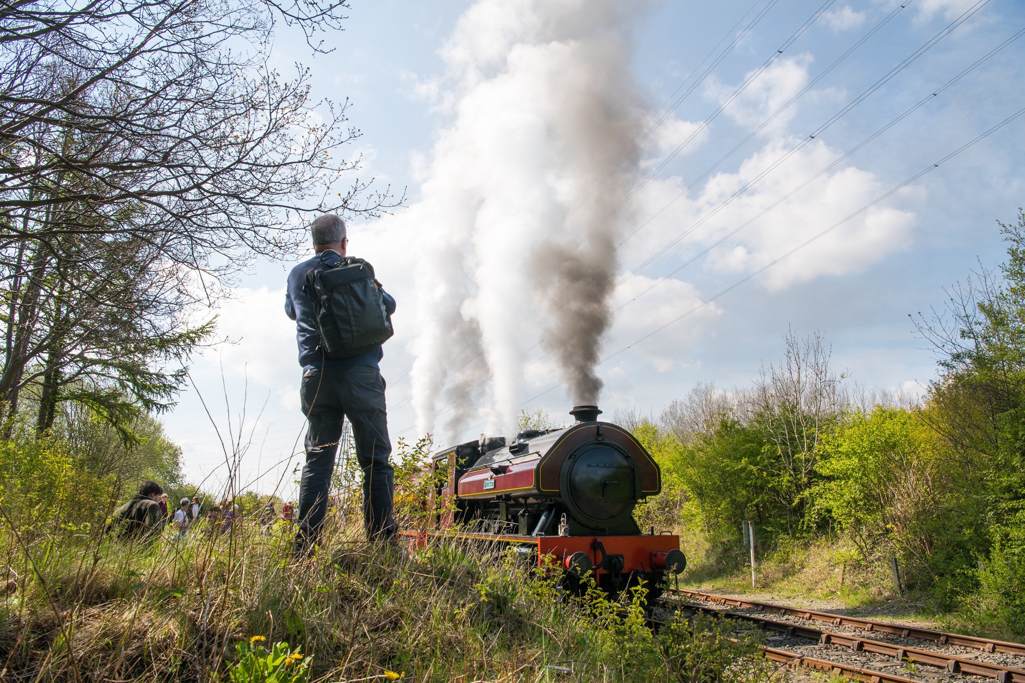 Steam train passing a man on a grass bank Steam train passing a man on a grass bank