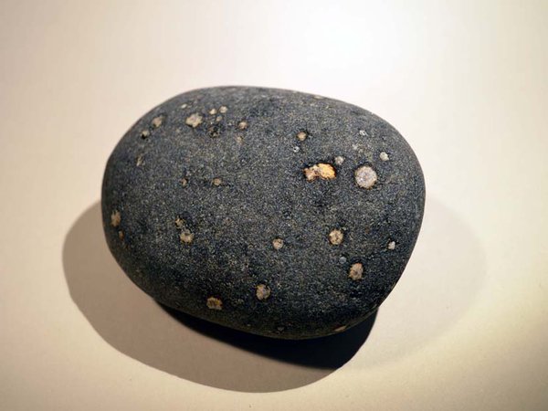 Close up photo of Quartz dolerite pebble, the white spots consist largely of the mineral calcite.