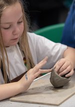 Young girl handling some pottery