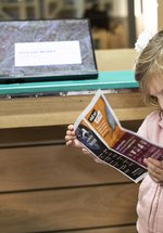 A young girl in a museum looking at a worksheet.