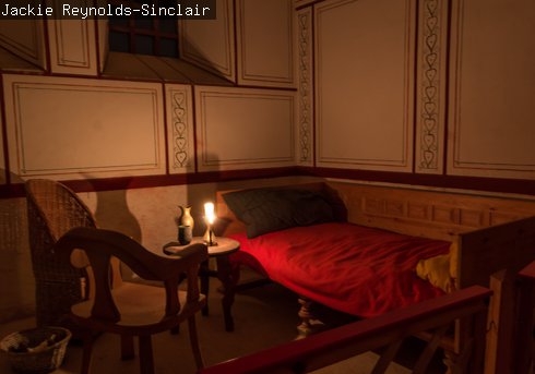 The reconstructed Commander's house lit by a candle 