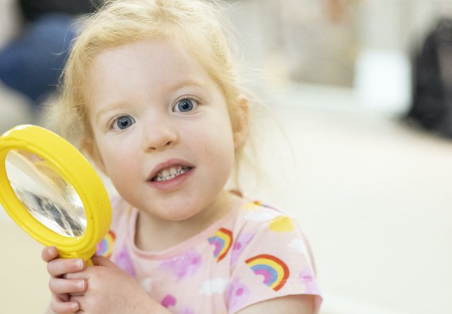 A young girl with a magnifying glass