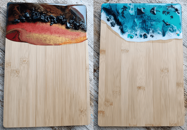 A photograph of two serving boards that have been decorated with blue and red acrylic pouring.